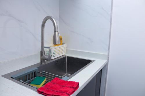 a kitchen sink with two red towels in it at Meteor Garden in Nairobi