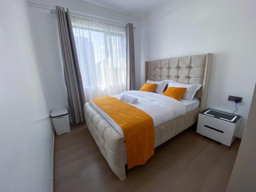 a bedroom with a large bed and a window at Meteor Garden in Nairobi