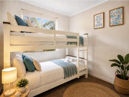 a bedroom with two bunk beds and a window at Canal escape with private jetty and huge deck in South Yunderup