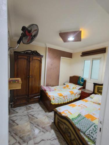 a bedroom with two beds and a dresser at لؤلؤة البحر in Alexandria