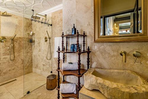 a bathroom with a shower and a tub and a sink at Batavia Boutique Hotel in Stellenbosch