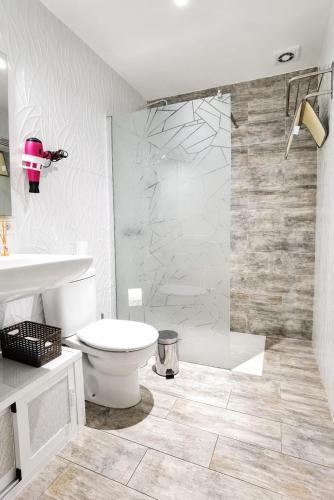 a bathroom with a toilet and a glass shower at Beachsunset apartamento para estancias temporales in Tacoronte