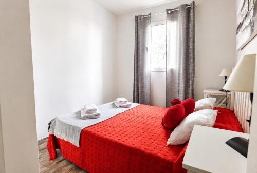 a bedroom with a red bed with red pillows at Beachsunset apartamento para estancias temporales in Tacoronte