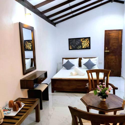 a bedroom with a bed and a table and chairs at Beach 365 in Nilaveli