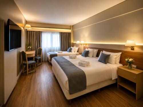 a hotel room with two beds and a television at Hotel Centuria Obelisco in Buenos Aires