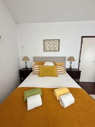 a bedroom with a large bed with yellow and green pillows at Cascais Historic Villa in Cascais