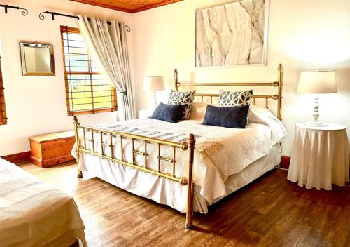 a bedroom with a large bed with blue pillows at Eikelaan Farm Cottages in Tulbagh
