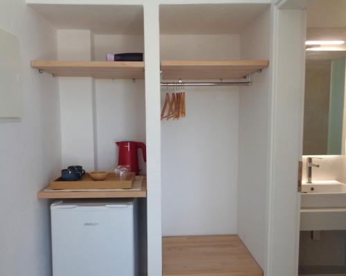 a small kitchen with a refrigerator and a sink at Villa Ploes in Agios Georgios