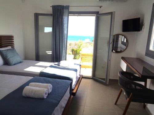 a hotel room with two beds and a view of the ocean at Villa Ploes in Agios Georgios