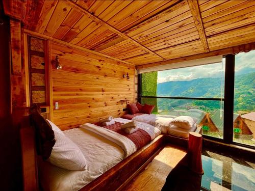 two beds in a room with a large window at YAYLAMİSUN SUITE HOTEL Luxury Nature Stay Çamlıhemşin in Çamlıhemşin