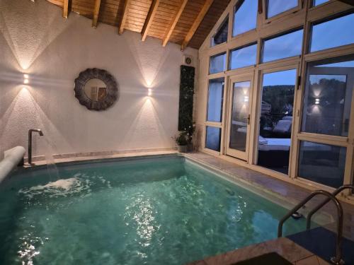 a swimming pool in a house with a large window at Hotel Schloßschenke in Idar-Oberstein