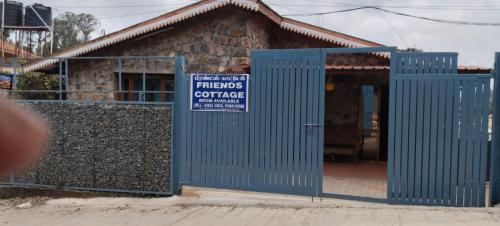 a blue building with a sign in front of it at Friends cottage in Coonoor