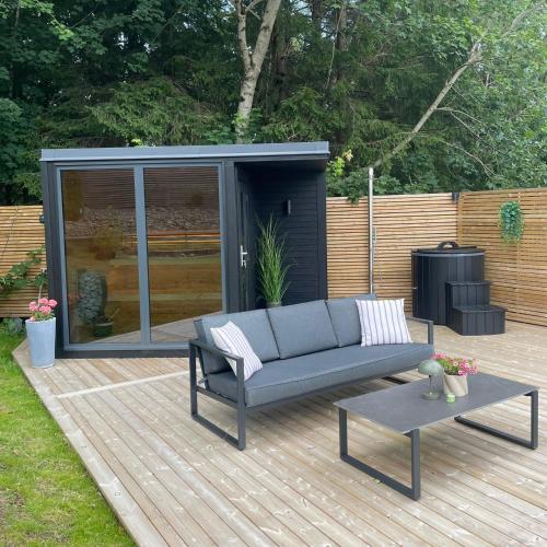 a couch and a coffee table on a deck with a shed at Landvetter Apartment in Landvetter