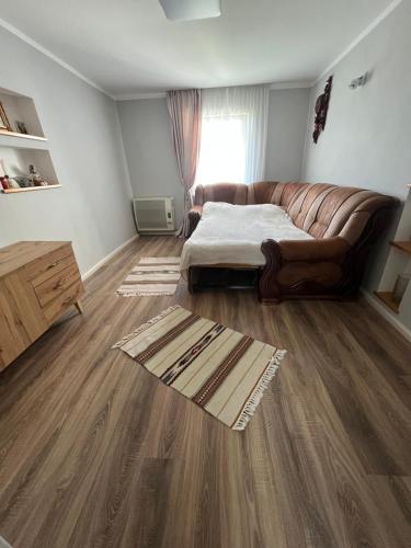 a living room with a couch and wooden floors at Садиба у Оксани in Verkhneye Sinevidnoye