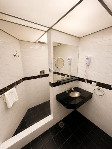 a bathroom with a sink and a mirror at Hotel Centuria Obelisco in Buenos Aires