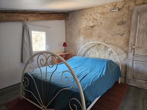 a bedroom with a bed with blue sheets and a window at Loft in Aujeurres