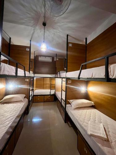 a room with three bunk beds in it at Cozy Rooms & Dormitory in Kozhikode