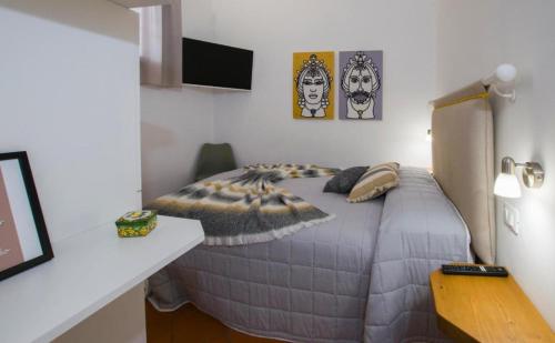 a bedroom with a bed in a room with a desk at Capo Rama Suites & Rooms in Terrasini
