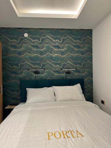 a bedroom with a large bed with a green wall at Apartman Porta 108 in Kruševac