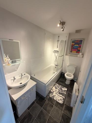 a bathroom with a tub and a sink and a toilet at Light & Airy flat, Amazing view in Whitefield