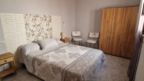 a bedroom with a bed and two chairs at Villa Izael AT-BA-00317 in Talavera la Real