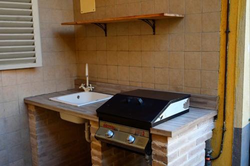 a bathroom with a sink and a counter with a stove at Casa Magenta Appartamento con giardino e bbq ad Asti in Asti