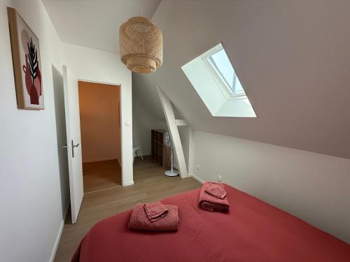 a bedroom with a red bed with two towels on it at Chtî arq in Arques-la-Bataille