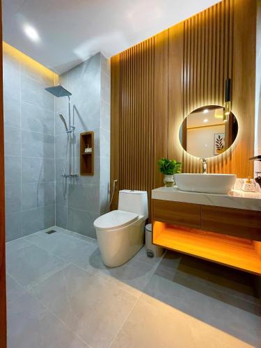 a bathroom with a toilet and a sink and a mirror at Vin Luxury Hotel in Quang Tri