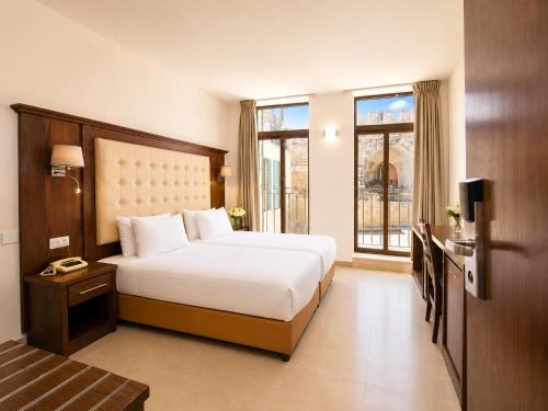 a hotel room with a bed and a window at The Annexe - by Gloria Hotel in Jerusalem