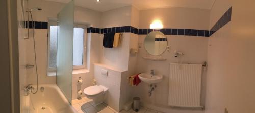 a bathroom with a tub and a sink and a toilet at Landhaus Wesermarsch in Achim