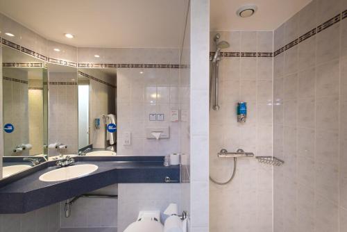 a bathroom with a sink and a shower at Holiday Inn Express Leeds City Centre by IHG in Leeds