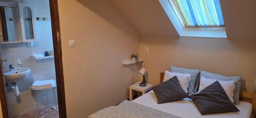 a bedroom with a bed and a bathroom with a sink at Határ Motel in Somoskőújfalu