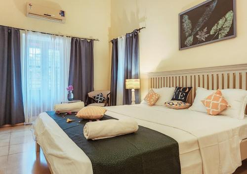 a bedroom with a large bed with pillows on it at Beach villa South Goa in Arossim-Cansaulim