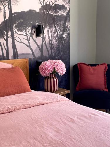 a bedroom with a bed and a vase with pink flowers at Le Cathedral View Colmar - Centre Historique - Parking privé gratuit in Colmar