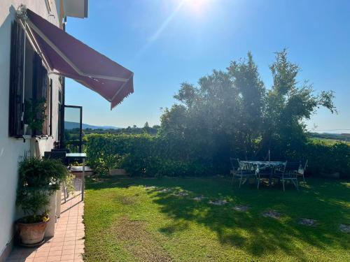 a patio with a table and chairs in a yard at Maison Margherita in Calmasino