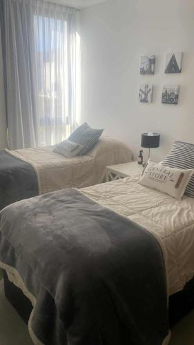 a bedroom with two beds and a window at Paseo Cibeles departamento in Villa Carlos Paz