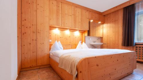a bedroom with a large bed in a wooden wall at Apartments B&B Pretermo in Badia