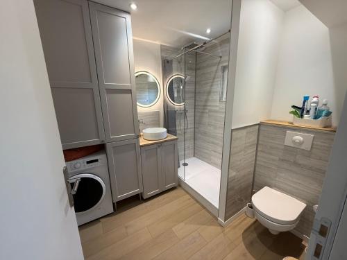 a bathroom with a shower toilet and a washing machine at Chtî arq in Arques-la-Bataille