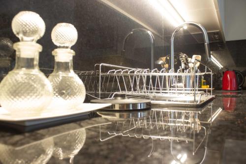 a dish rack with two glass bottles on a counter at Bright Downtown Apartment in Porto