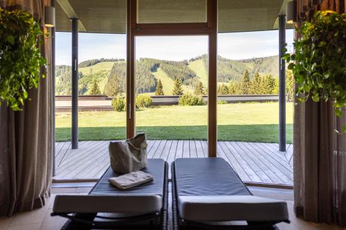 a porch with two chairs and a view of a mountain at Almwellness Hotel Pierer in Fladnitz an der Teichalm