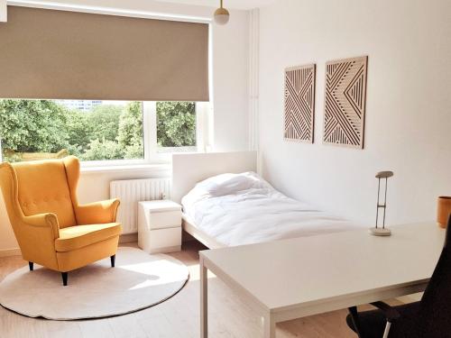 a bedroom with a bed and a desk and a chair at Apartment with skyline view in Eindhoven
