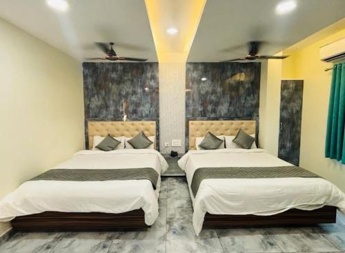 a bedroom with two beds in a room at HoTEL MADHAVI ELITE in Vijayawāda