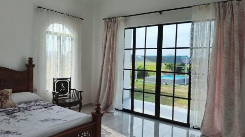 a bedroom with a large window with a view of a pool at Homestay Kamila Mersing in Mersing