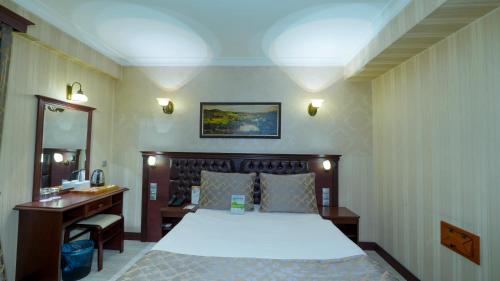 a hotel room with a bed and a desk and a desk at Oğlakcıoğlu Park Otel in İzmir