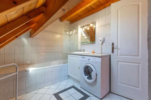 a bathroom with a washing machine and a tub at Gîte Viscos - L'escapade en famille l Ô Domaine de Geu in Geu