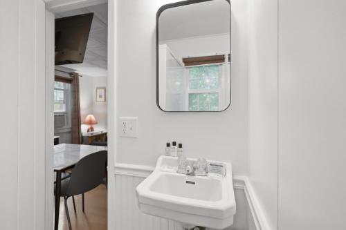 a white bathroom with a sink and a mirror at Phoenicia Lodge in Phoenicia