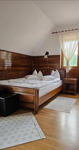 BilborにあるCasa la munteの木製のヘッドボードが付いた大きなベッドのある寝室