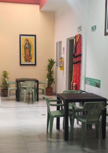 a room with tables and chairs and a painting on the wall at Hotel Matias Real in Buga