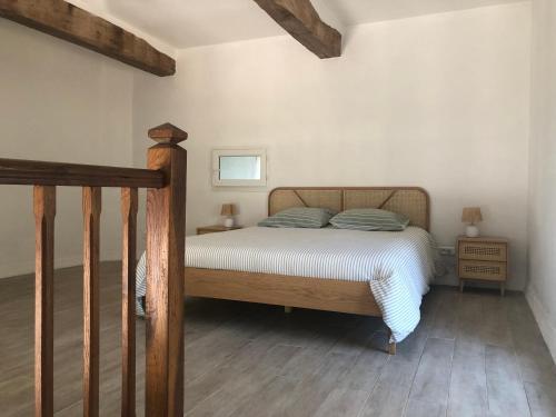 a bedroom with a bed with a wooden head board at Pigeonnier La Carole 35m2 in Monlezun