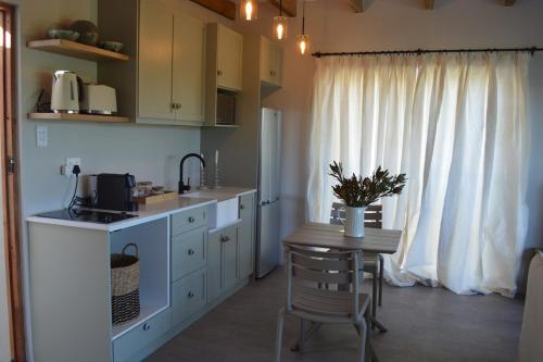 a kitchen with a table and a small table with a chair at 2 Bedroom sea view studio in Onrus in Hermanus
